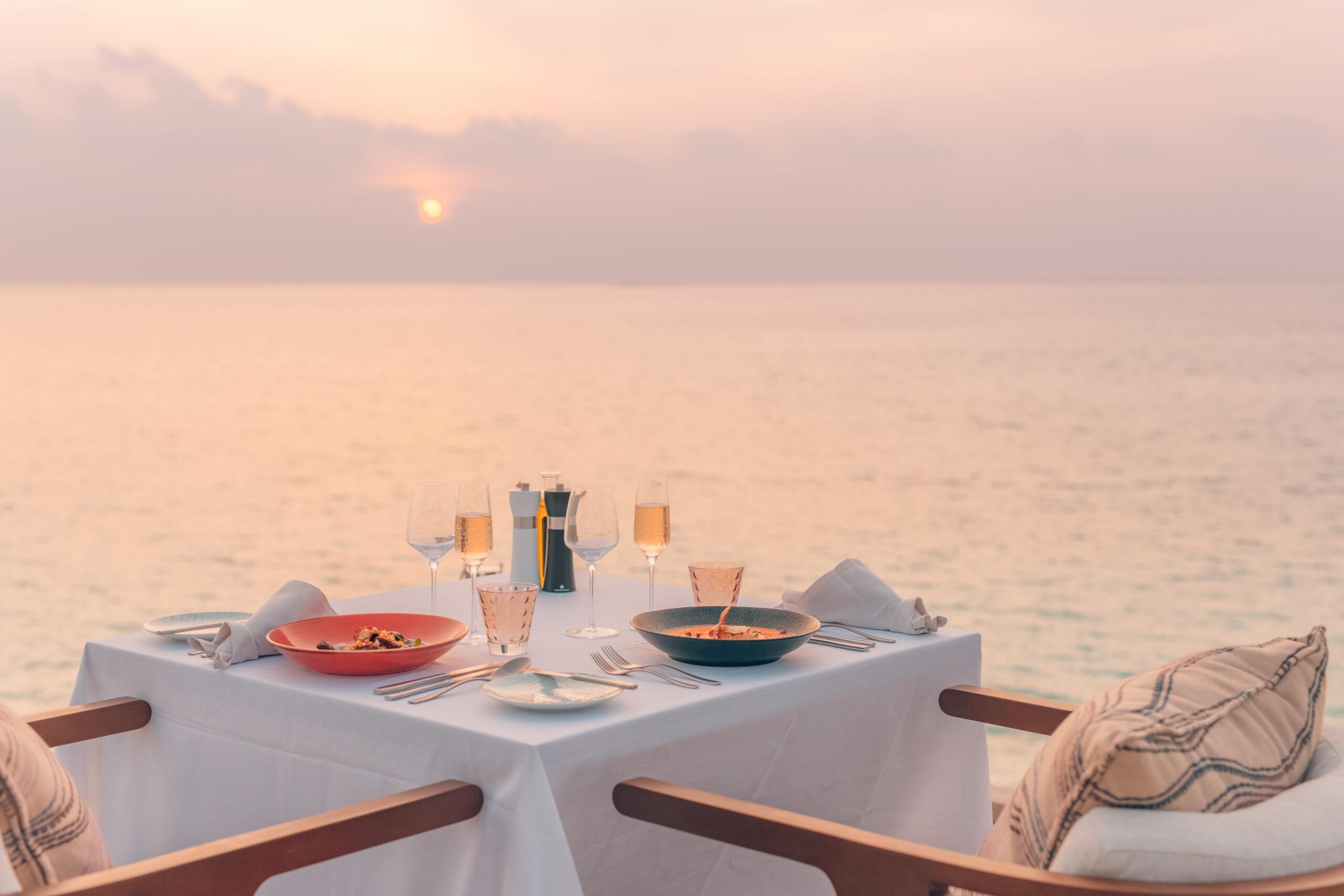 seascape view during sunset with a romantic dining table setup